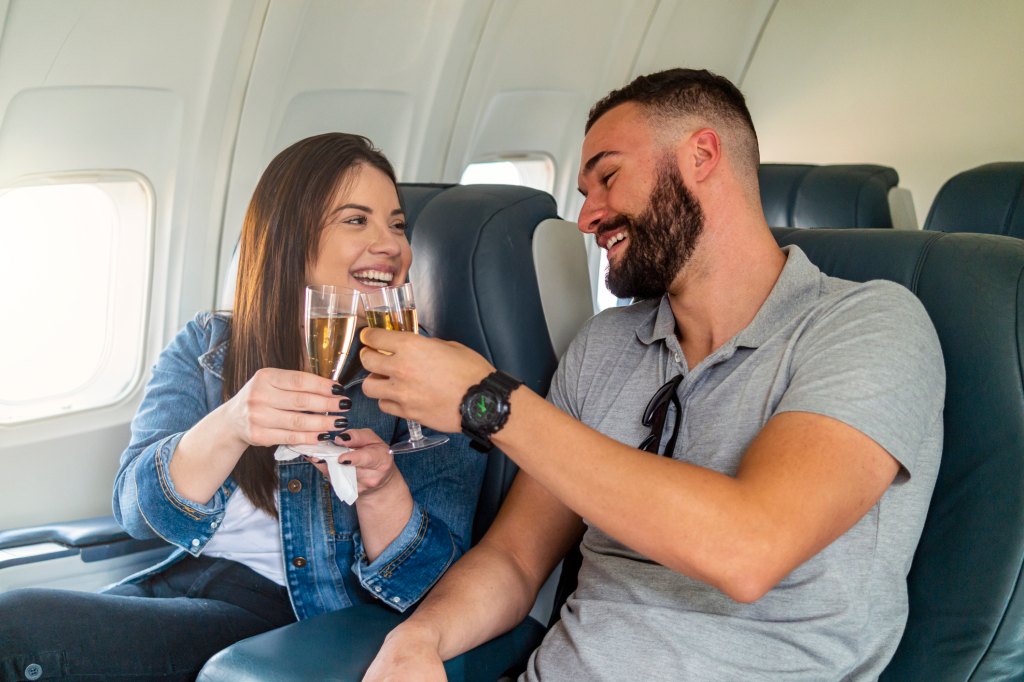 couple toasting champagne on airplane